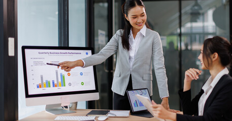 Two busy professional business asian working in office with computer. two female executive manager talking colleague having conversation showing software online solution on laptop.
