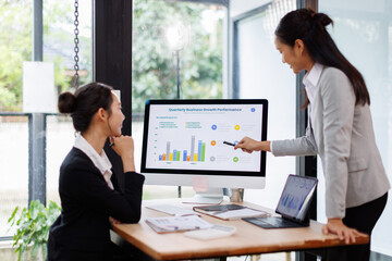 Two busy professional business asian working in office with computer. two female executive manager talking colleague having conversation showing software online solution on laptop.
