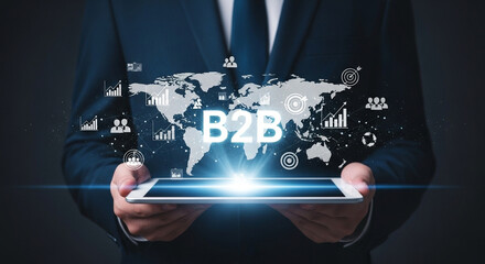 Man holding tablet displaying b to b over world map with business related icons in dark background