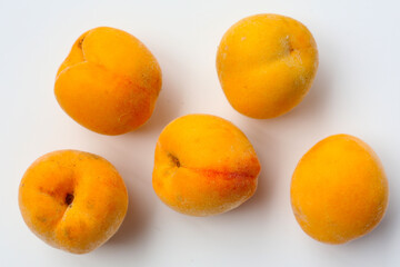 Fresh ripe apricots on a white background.