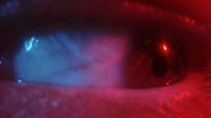 Macro shot of real human eye illuminated by red and blue light