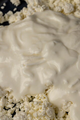 sprinkled with liquid sour cream, lumps of freshly made fermented milk product, closeup