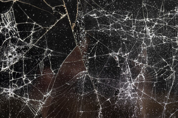 broken with a lot of damage and pieces of glass on a black background, thin glass broken into pieces