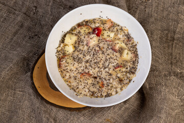 chia seeds in oatmeal with fruits, quickly cooked oatmeal porridge with fruits and berries and lots of chia seeds, closeup