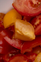 preparation of salad from sliced tomatoes with spices and olive oil, closeup