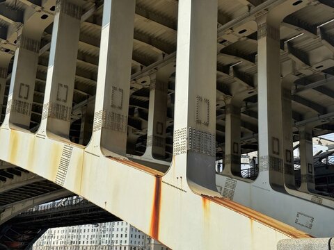A close-up of the structural steel supports beneath a bridge shows intricate engineering.
Concept of: Structural integrity.