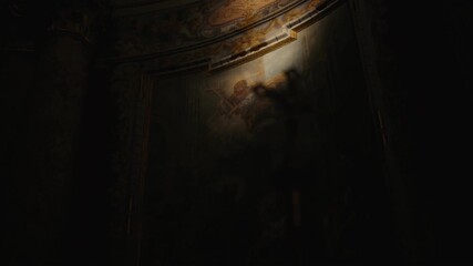 Shadowy blurred cross in historical church with old wall-painting creates blessed atmosphere of silence and tranquility
