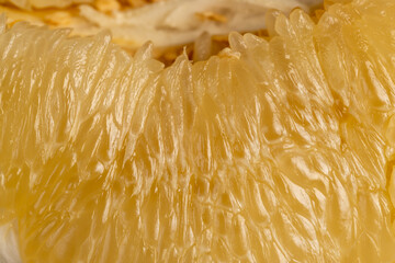 sweet juicy citrus fruit peeled, pieces of delicious and sweet citrus fruit while preparing it for...