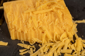 fresh yellow cheese made from milk , preparation of dairy products during cooking, details of delicious cheese in small pieces