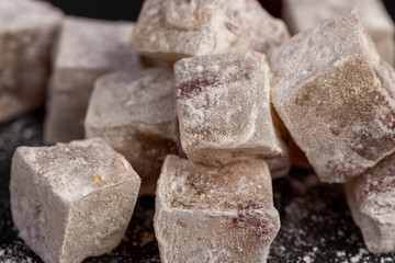 cubes of sweet Turkish delight with the addition of dried red berries in powdered sugar