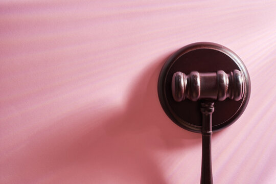 top view of gavel hammer against pink background with copoy space.
