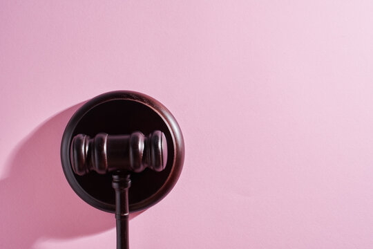 top view of gavel hammer against pink background with copoy space.