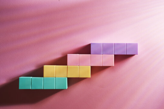 colorful  toy block stairs on pink background.