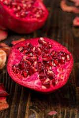 sliced pomegranate on a table close up, sweet red pomegranate cut into pieces during cooking