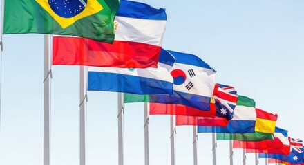 Multiple national flags waving in the wind against clear blue sky