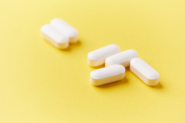 Magnesium tablets on bright paper background. Soft focus. Close up. Copy space	