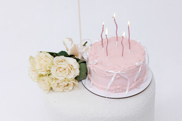 Celebration with a pink birthday cake and white roses on a decorative table