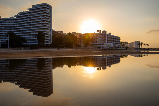 Vistas de una playa y reflejo de edificios