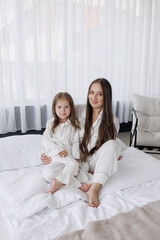 Mother and daughter enjoying a cozy moment together in a bright room during the morning