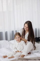 Mother and daughter enjoying a cozy moment together at home in the morning light
