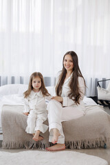 Mother and daughter enjoying a cozy morning in a bright bedroom together