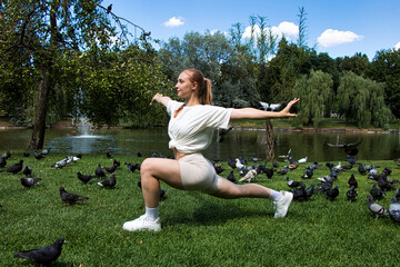 Young woman doing yoga in the park on a sunny summer day