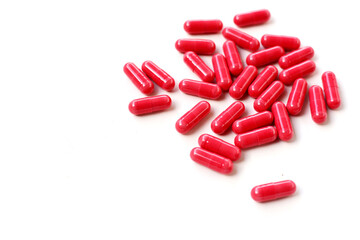 Red astaxanthin supplement capsules on a white background.