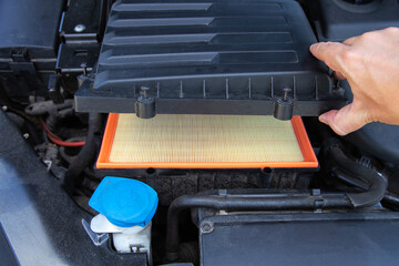 Installing a new clean air filter in the engine compartment of a car to clean the air in the car...