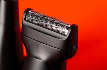 Modern shaving head on a red background. Beard care, close-up