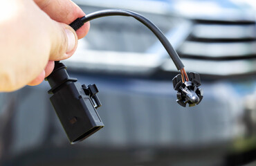 Black car outside air temperature gauge against car headlight background, industry