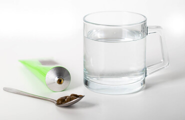 Urological paste on herbs against the background of a glass of water. Treatment of infectious...
