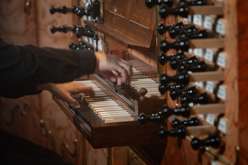 A pianist playing on an antique church organ. Hands with intentional blurry.