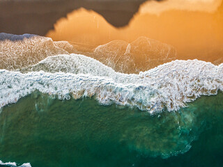 Aerial View of Ocean Waves Hitting Sandy Shore. Aerial drone view. natural background