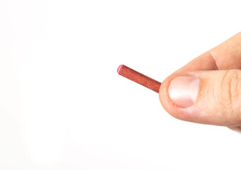 Firecracker with a wick in hand on a white background, isolate, close-up. Copy space for text....