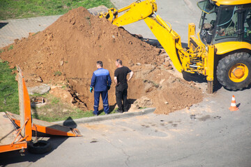 The emergency service blocked the road to lay gas pipes in the courtyard of the house. Workers are...