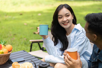 Couple enjoying drinks and laughter in a sunny garden
