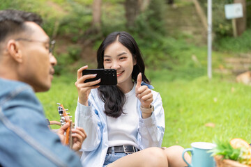 Outdoor Fun. Young woman capturing joyful moment with smartphone in nature.
