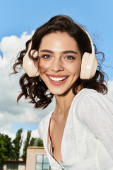 Joyful young woman enjoying summer outdoors with blue sky and bright smile