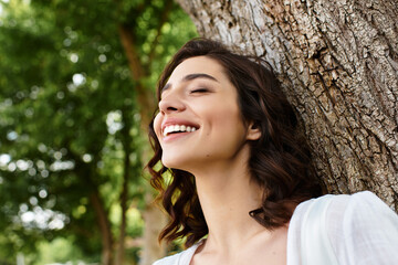 Sunny summer day with a young woman enjoying nature in a peaceful park