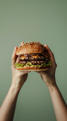 Delicious Double Cheeseburger Held by Hands Against Pastel Green Backdrop