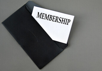 MEMBERSHIP - word on white paper on a black envelope with a magnifying glass