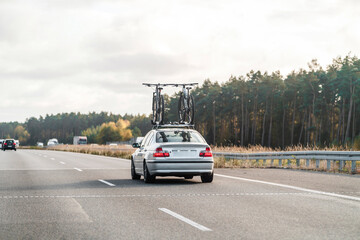 Sedan on open road carrying bicycles