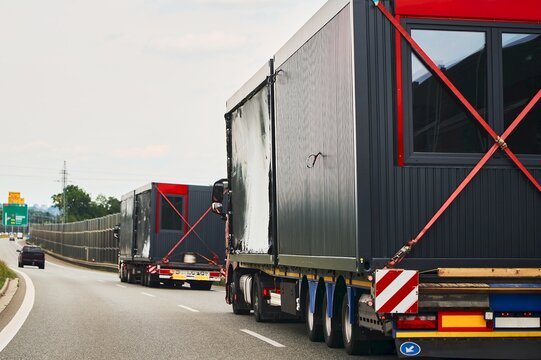 Large trucks transporting portable buildings