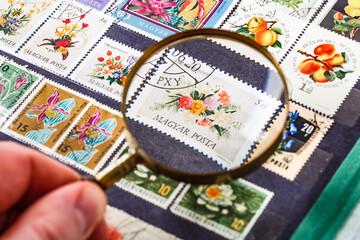Postage stamps. Collection of stamps and magnifying glass. Collection of world stamps in a stack demonstrates the theme of flora and fauna. Postage stamps of different countries and times