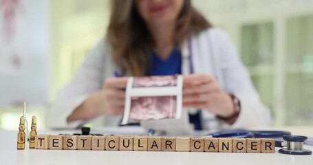 Wooden cubes form phrase Testicular Cancer showing disease focus near scans. Doctor studies scan images creating atmosphere of male health awareness