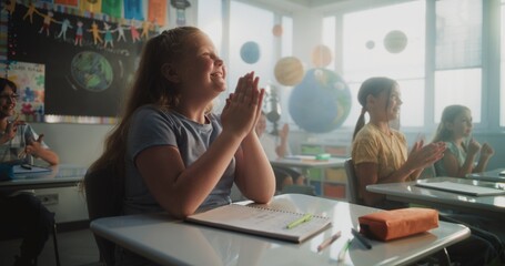 Cheerful Diverse Kids Sitting at Desks, Clapping Their Hands, Interacting with Teacher During...