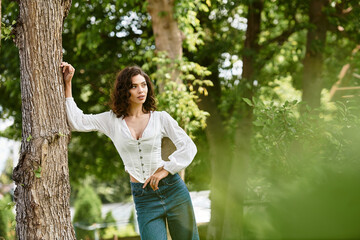 Lovely young woman enjoying summer in a vibrant green park under the warm sun