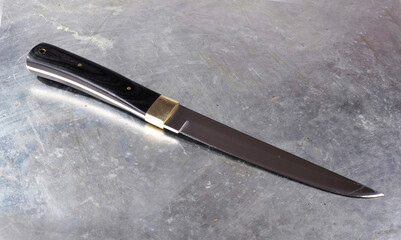 Hunting knife, with a wide single-sided sharpened blade, on an isolated background.