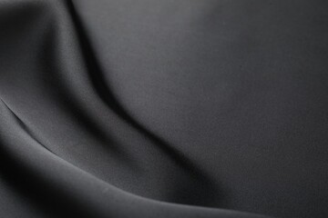 Fototapeta premium Crumpled black silk fabric as background, closeup