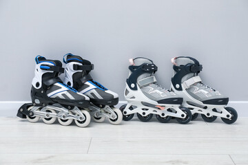 Pairs of roller skates on floor near white wall